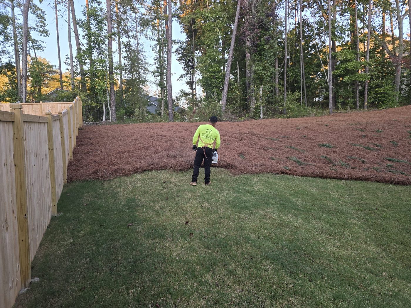 Crew member finishing pinestraw install